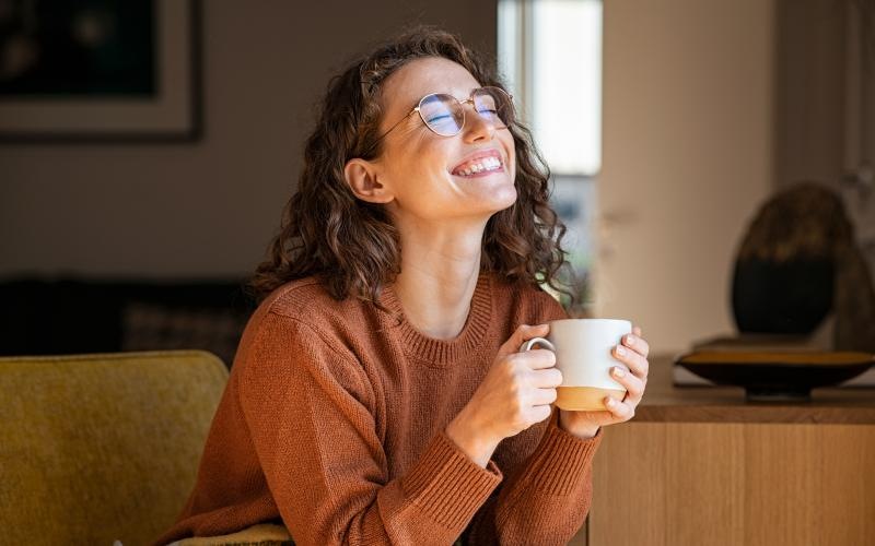 a woman wearing glasses and holding a cup